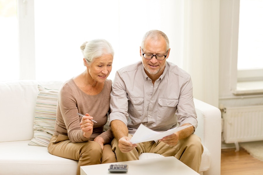 Senior couple with papers and calculator at home. What is AFUE?