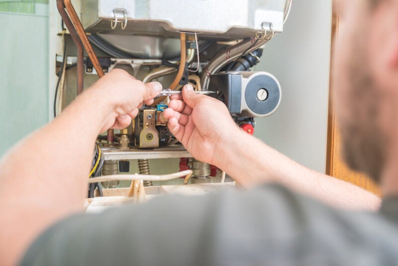 Technician performing fall maintenance on a Gas Furnace